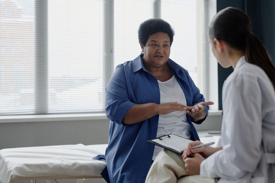 Senior Black Woman gesturing during consultation with medical provider